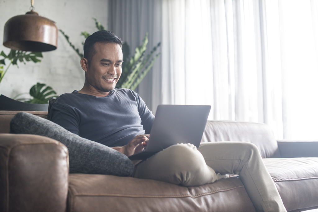 Man sitting with laptop smiling