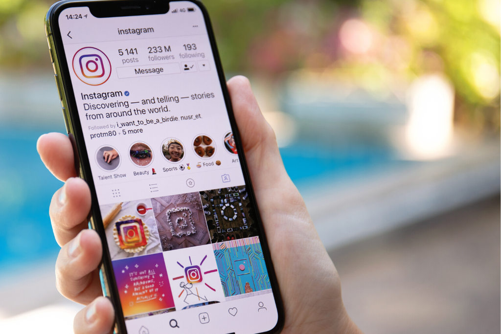 How to Make Unique Instagram Highlight Covers (For Free!) hand holding an iPhone and scrolling Instagram