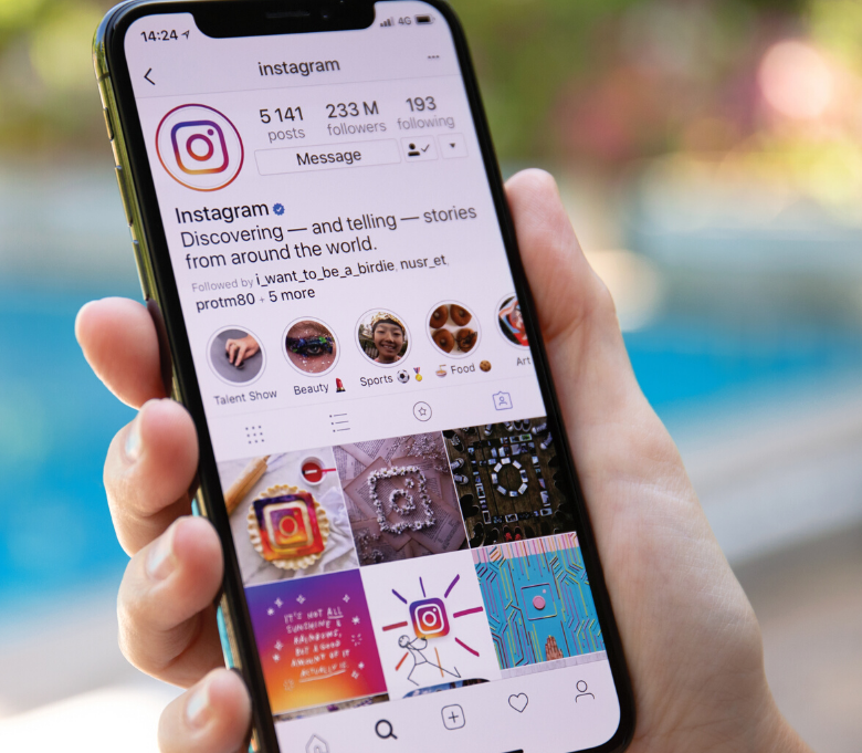 hand holding an iPhone and scrolling Instagram